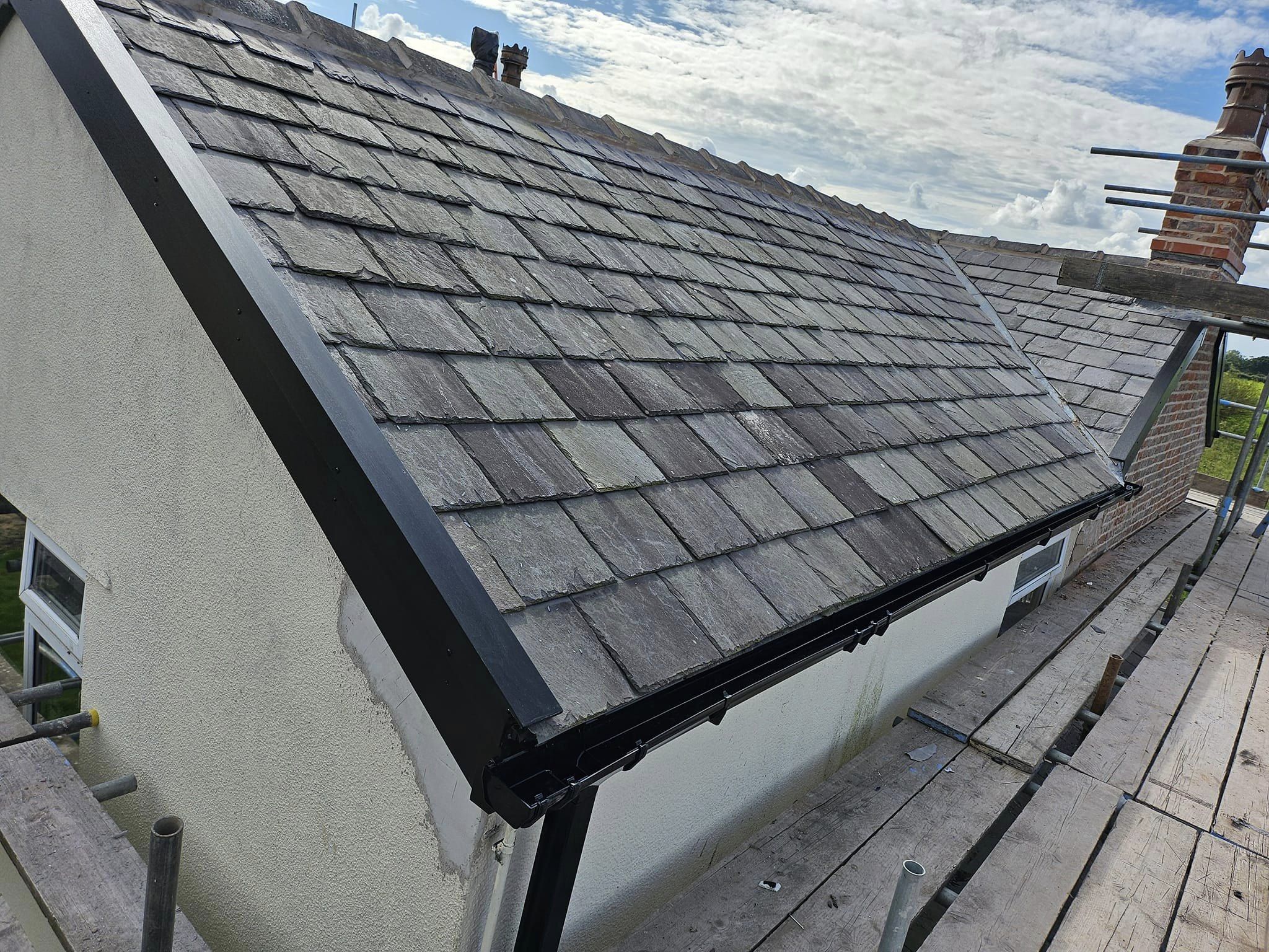 Grey slate-effect tiles with a new black fascia and gutter