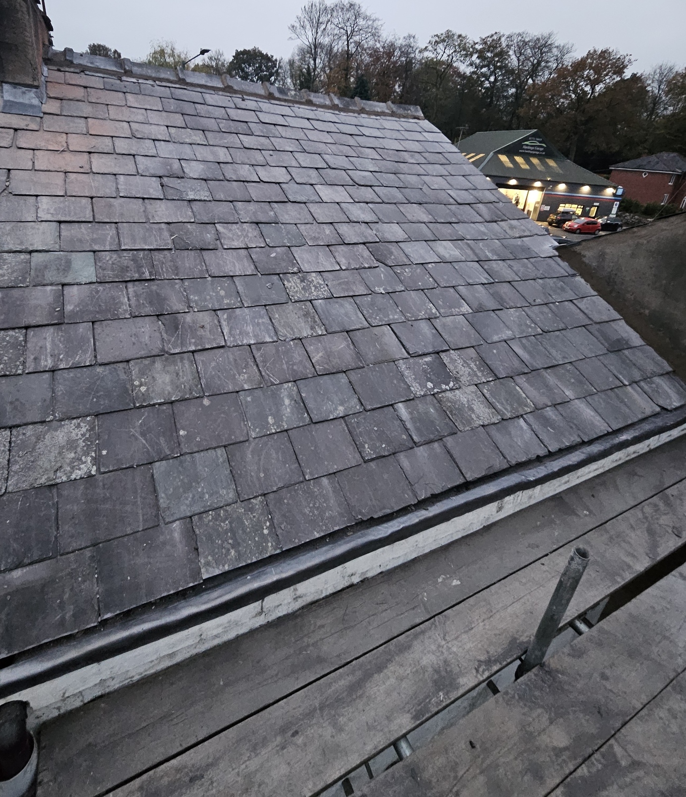 Dark slate roof photographed from scaffolding with new gutter and fascia